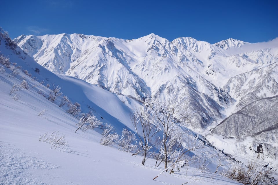 A snow-covered mountain range with clear blue skies.