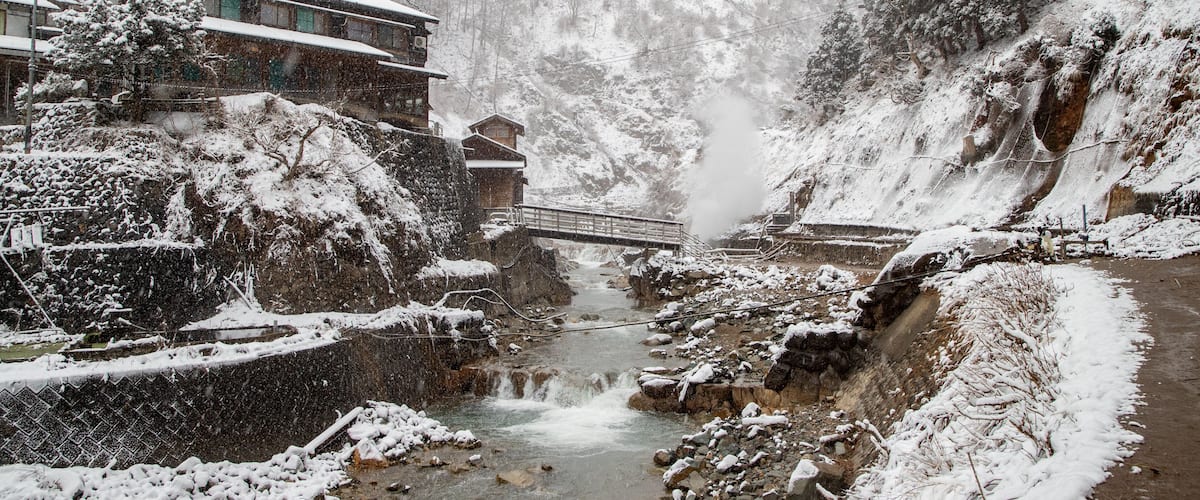 Jigokudani Monkey Park showing a small town or village, a river or creek and snow