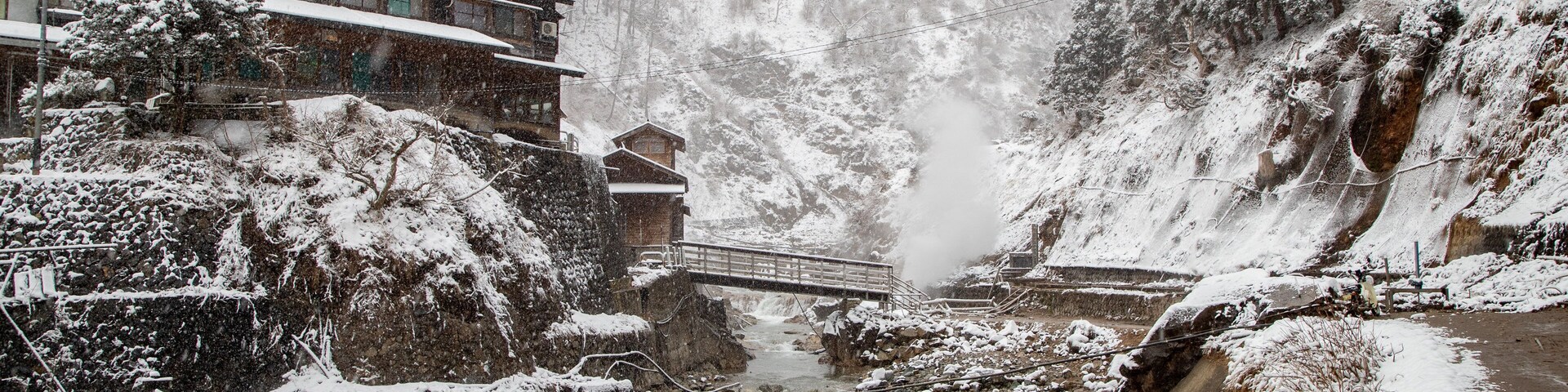 Jigokudani Monkey Park showing a small town or village, a river or creek and snow