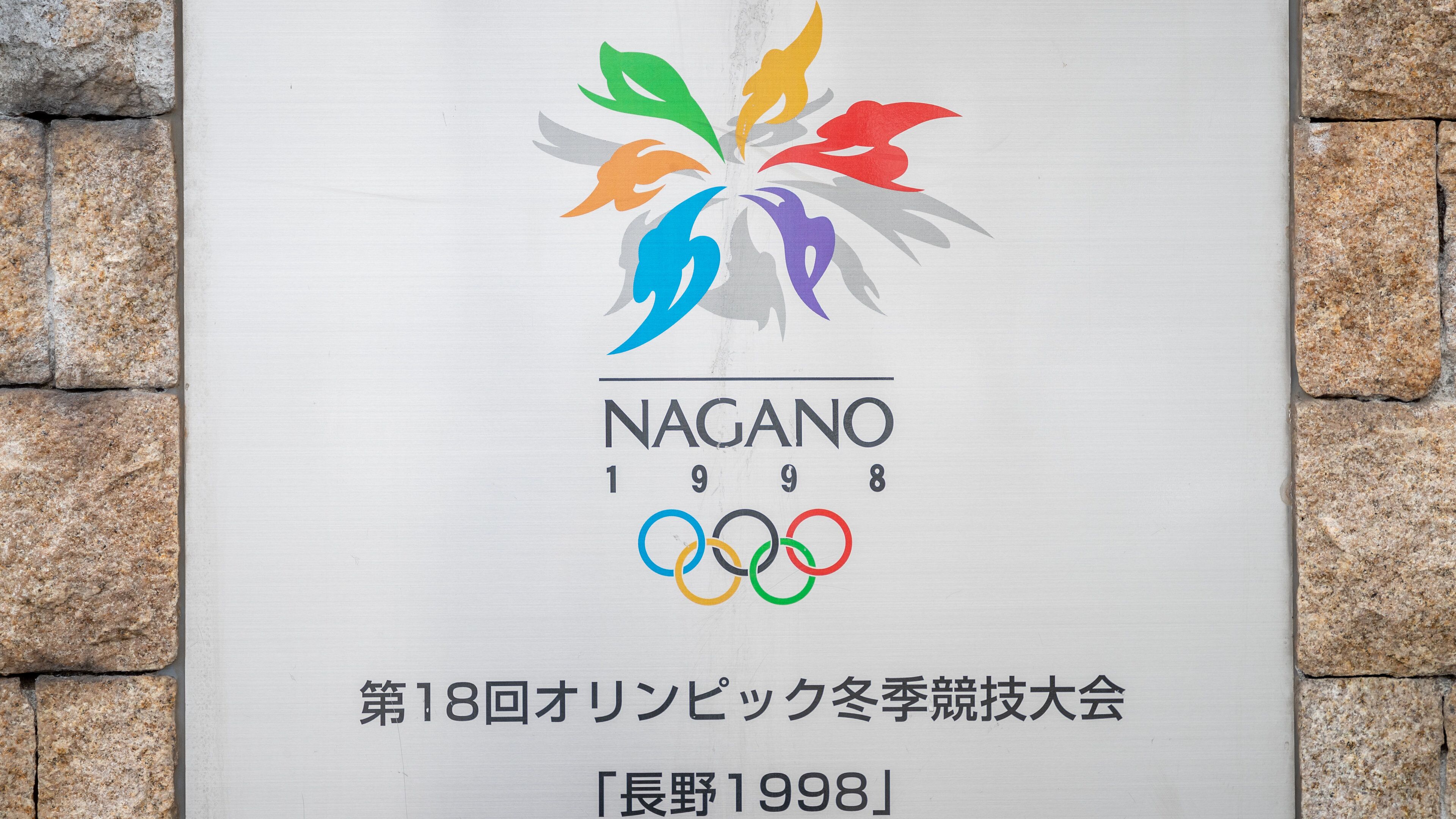A Nagano 1998 Olympic Games sign with a colorful logo and Olympic rings.