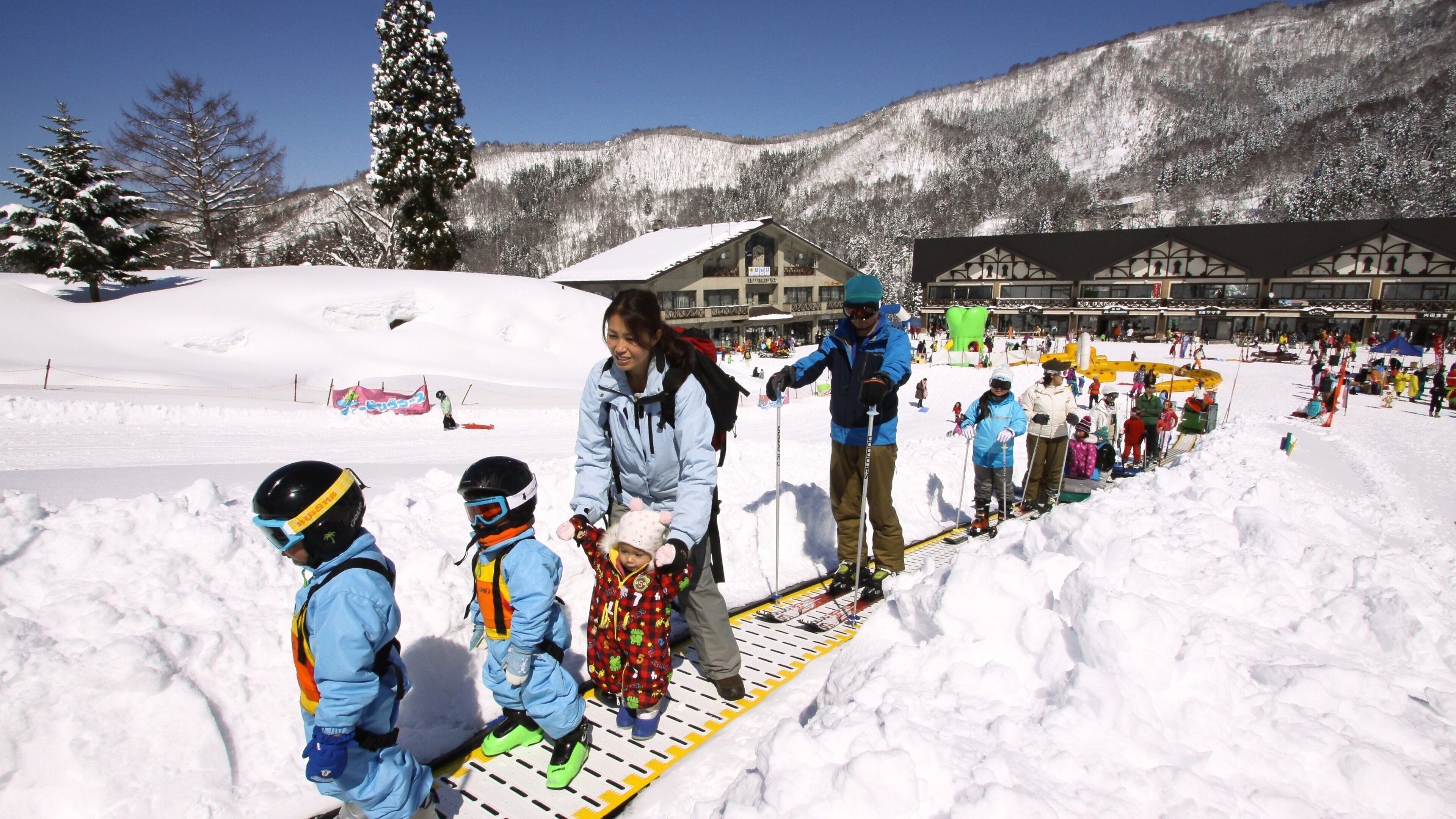 Una pista de esquí con personas esquiando y practicando snowboard.