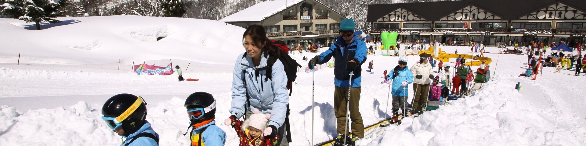 Una pista de esquí con personas esquiando y practicando snowboard.