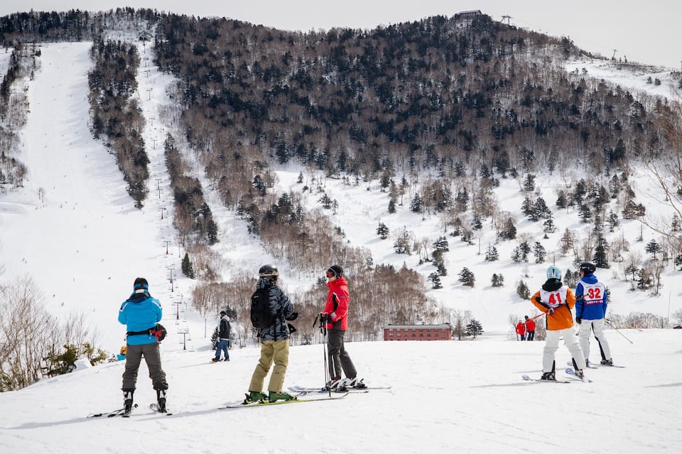 A ski slope with skiers and a ski lift.