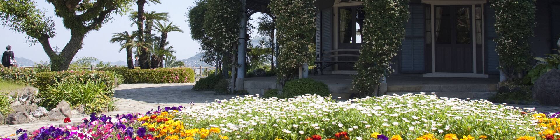 A traditional building with a tiled roof, surrounded by a vibrant flower garden.