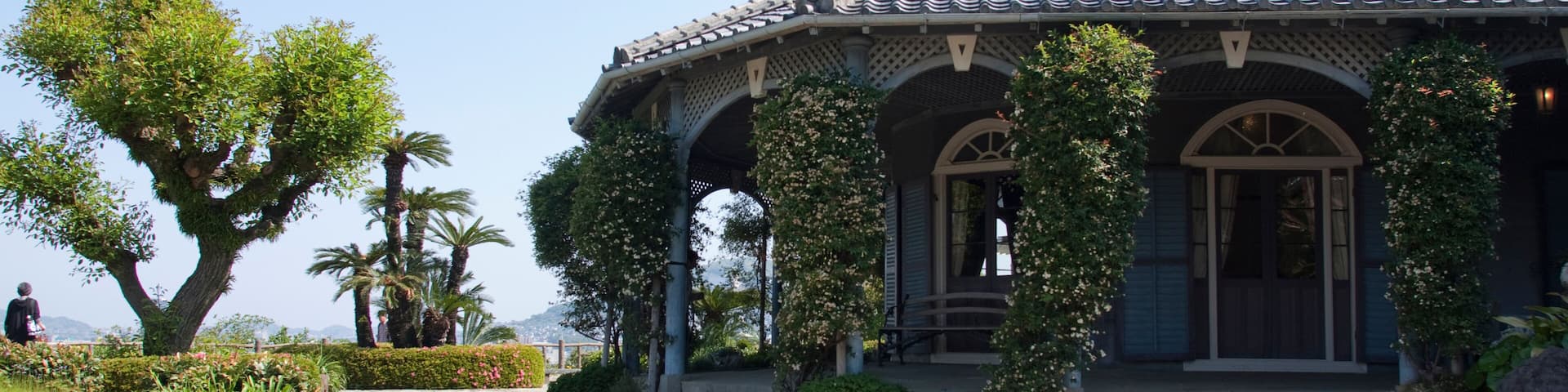 A traditional building with a tiled roof, surrounded by a vibrant flower garden.