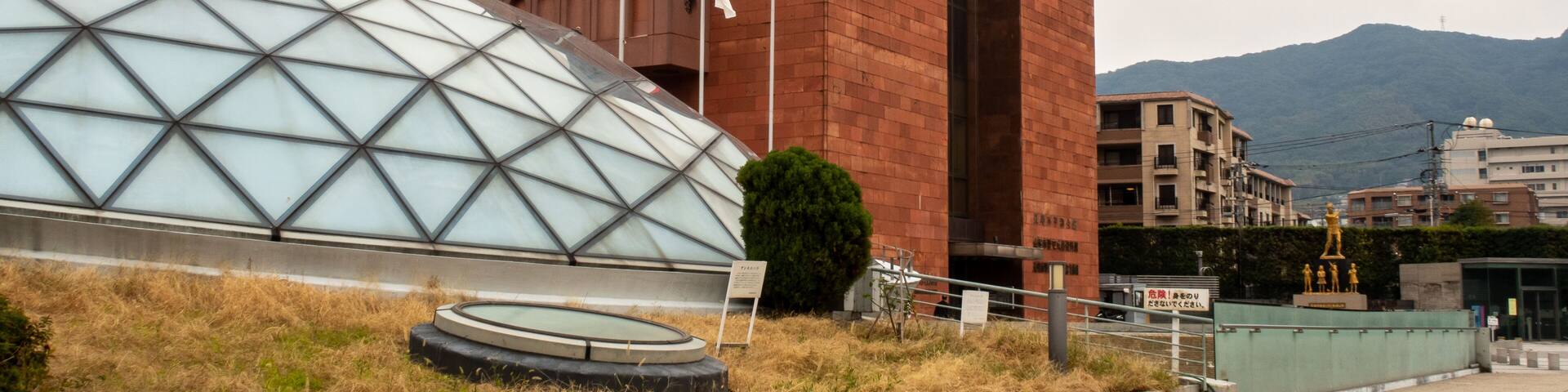A red brick building with a glass dome structure in front.