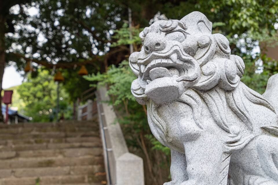 A stone lion statue at the base of a staircase.