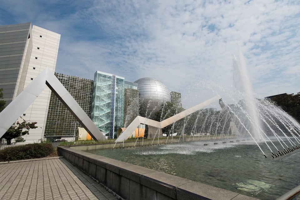 Ein moderner Gebäudekomplex mit einem Wasserspeier im Vordergrund.