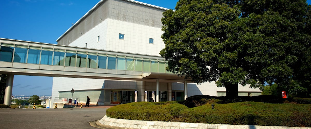 A modern building with a large tree in front.