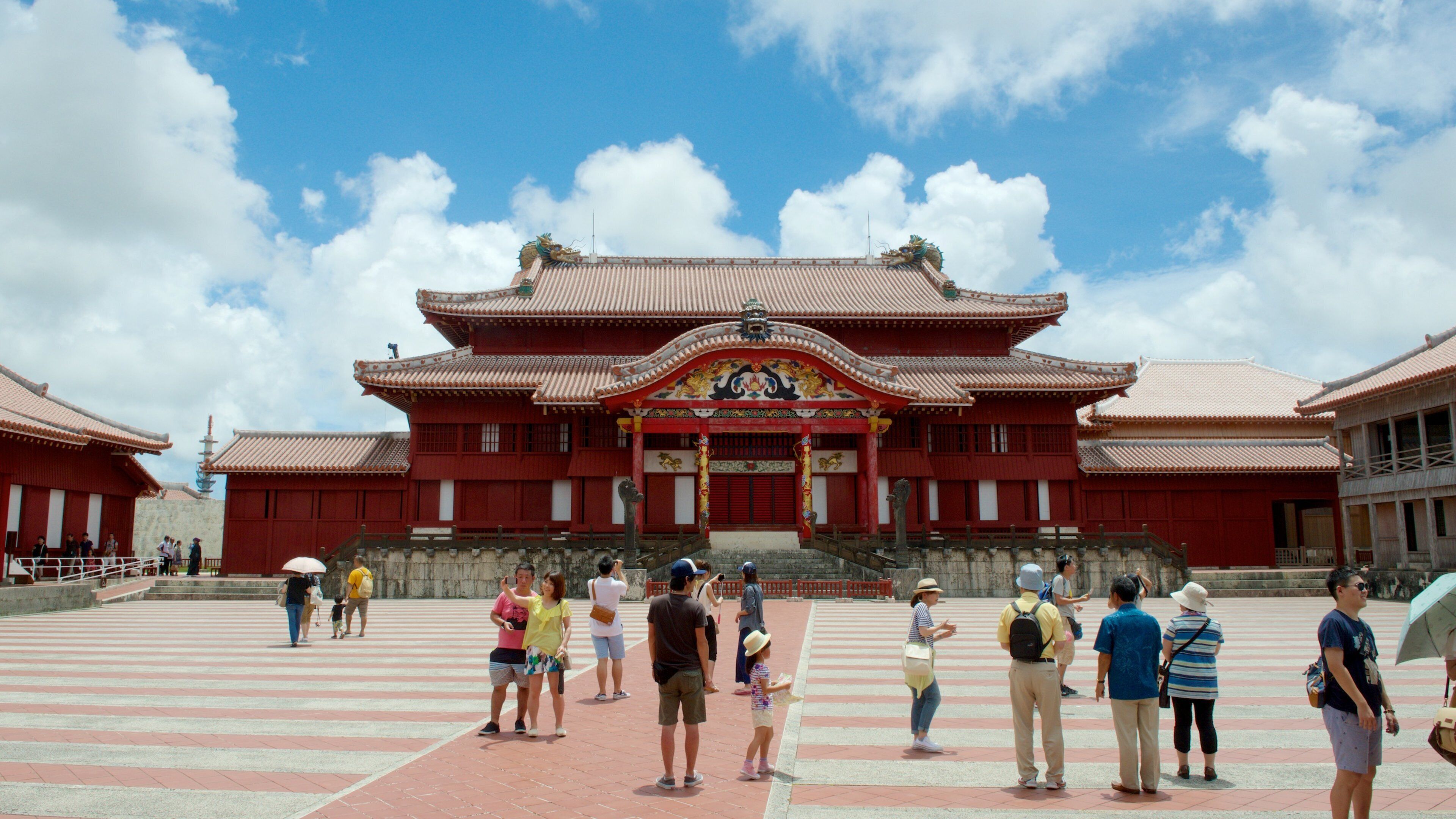 A traditional red building with ornate decorations and a large staircase leading up to the entrance.