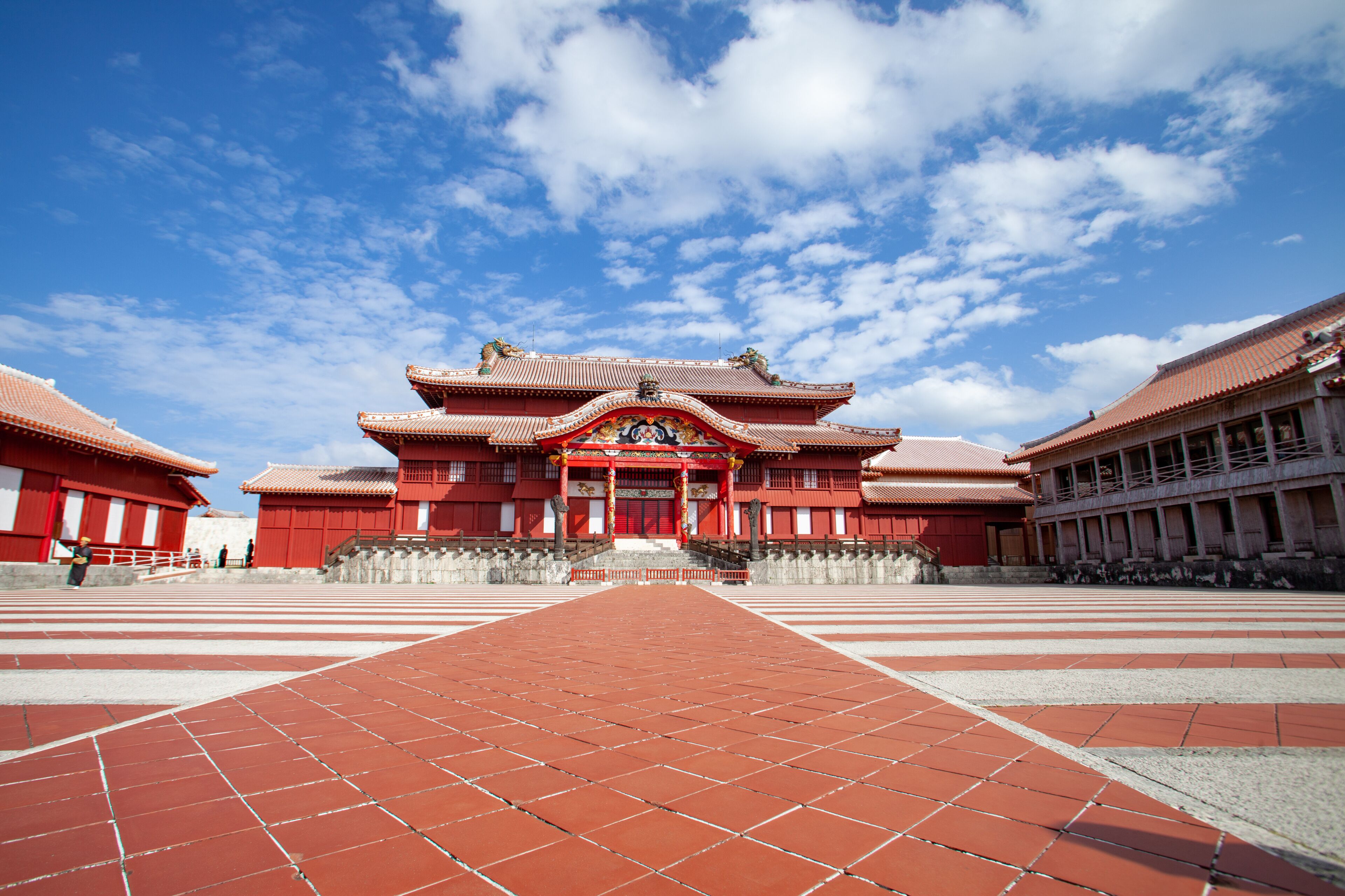 A traditional red building with a tiled courtyard.