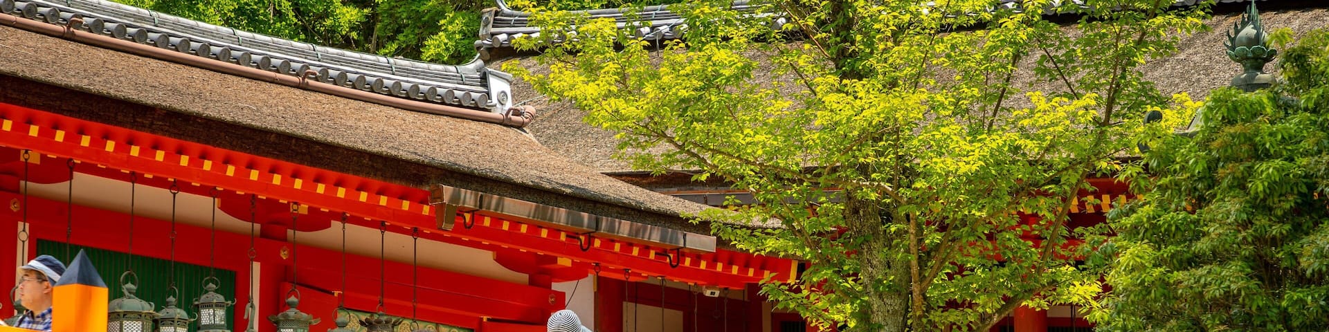 Un templo japonés tradicional con paredes rojas y blancas, techo de tejas y una escalera de piedra que lleva a la entrada.