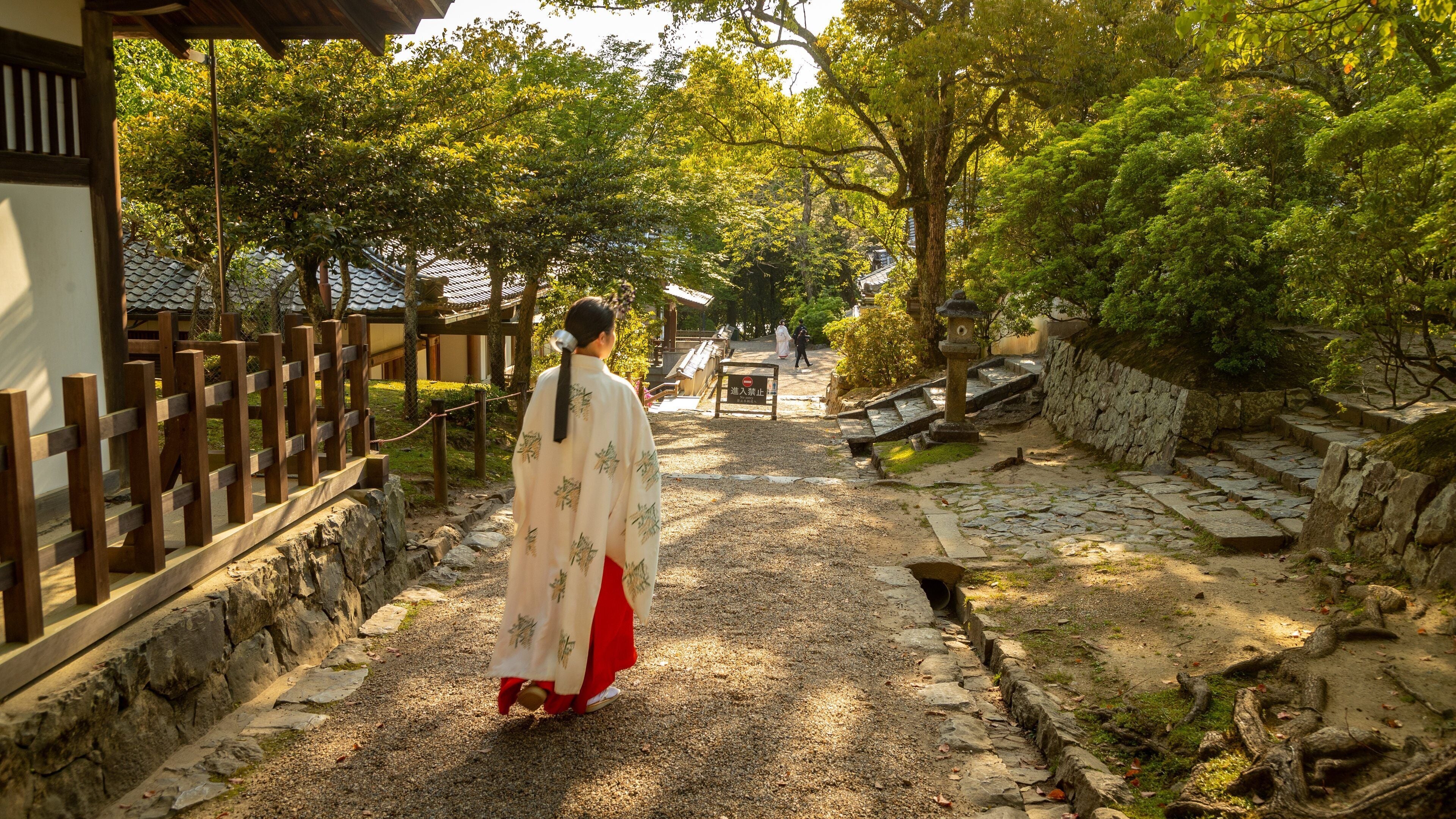 Kasuga Shrine featuring a garden as well as an individual femail