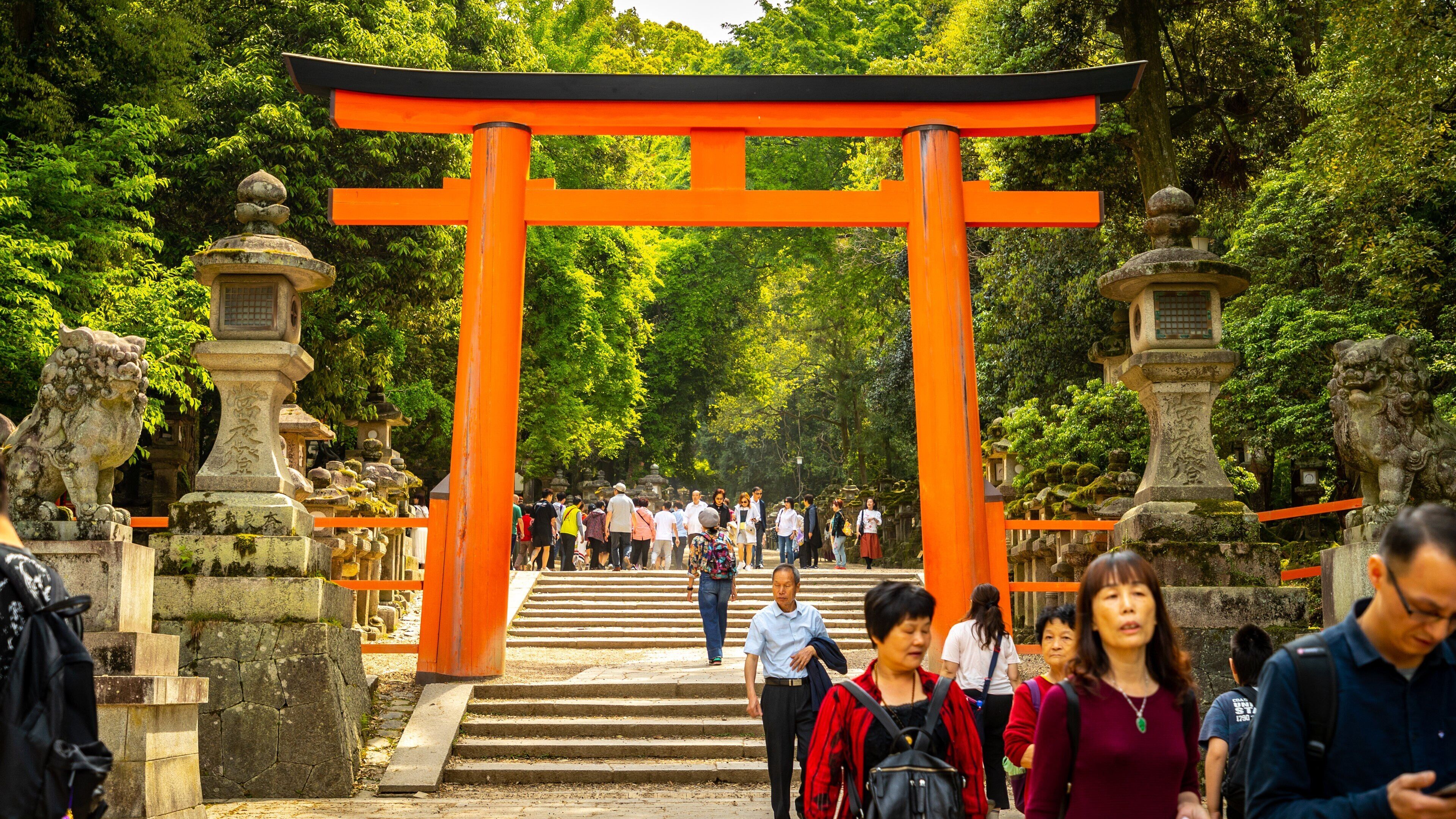 Kasuga Shrine featuring a garden and heritage elements as well as a small group of people