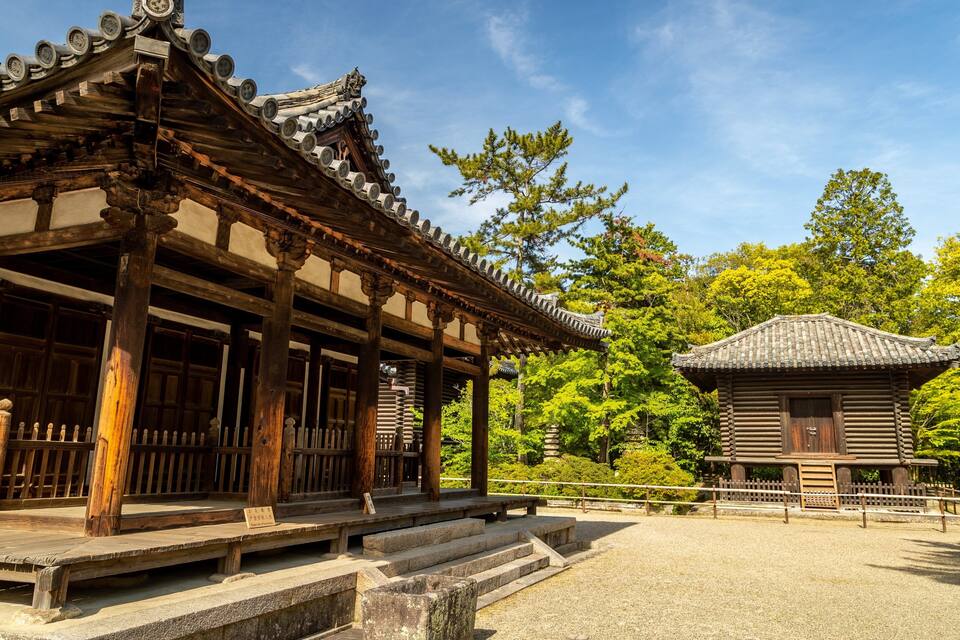 A traditional Japanese temple with wooden architecture and a stone pathway.