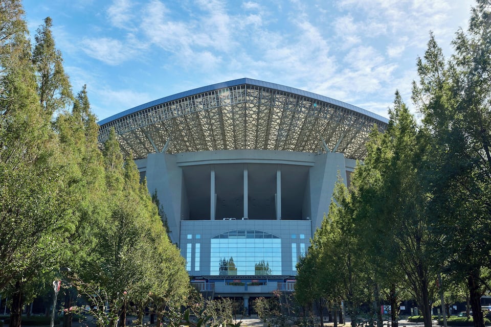 Een modern gebouw met een grote glazen gevel en een opvallende dakconstructie.