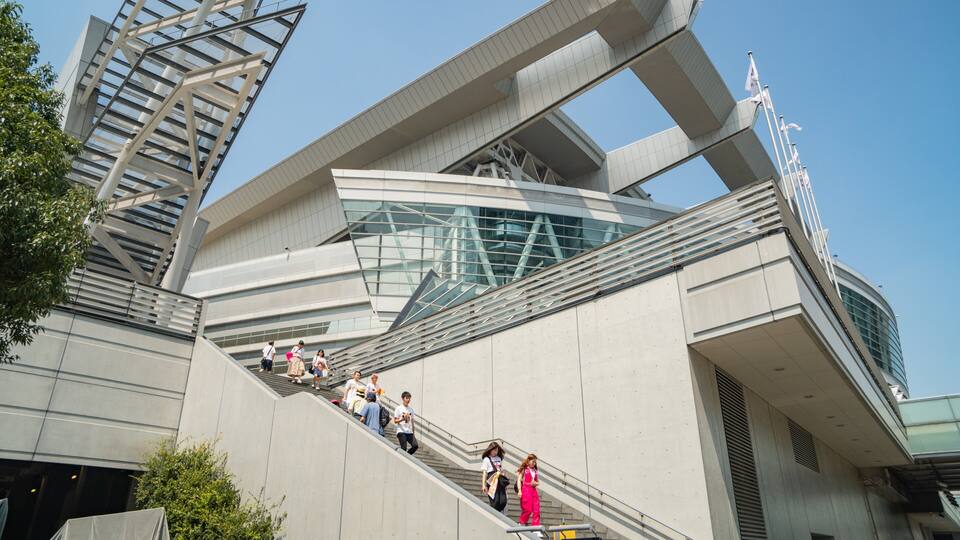A modern architectural building with a unique geometric design, featuring a prominent staircase and glass facade.