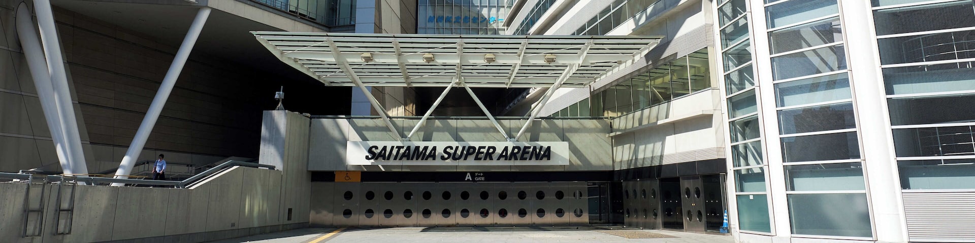 A modern architectural structure with a sign reading "SAITAMA SUPER ARENA".