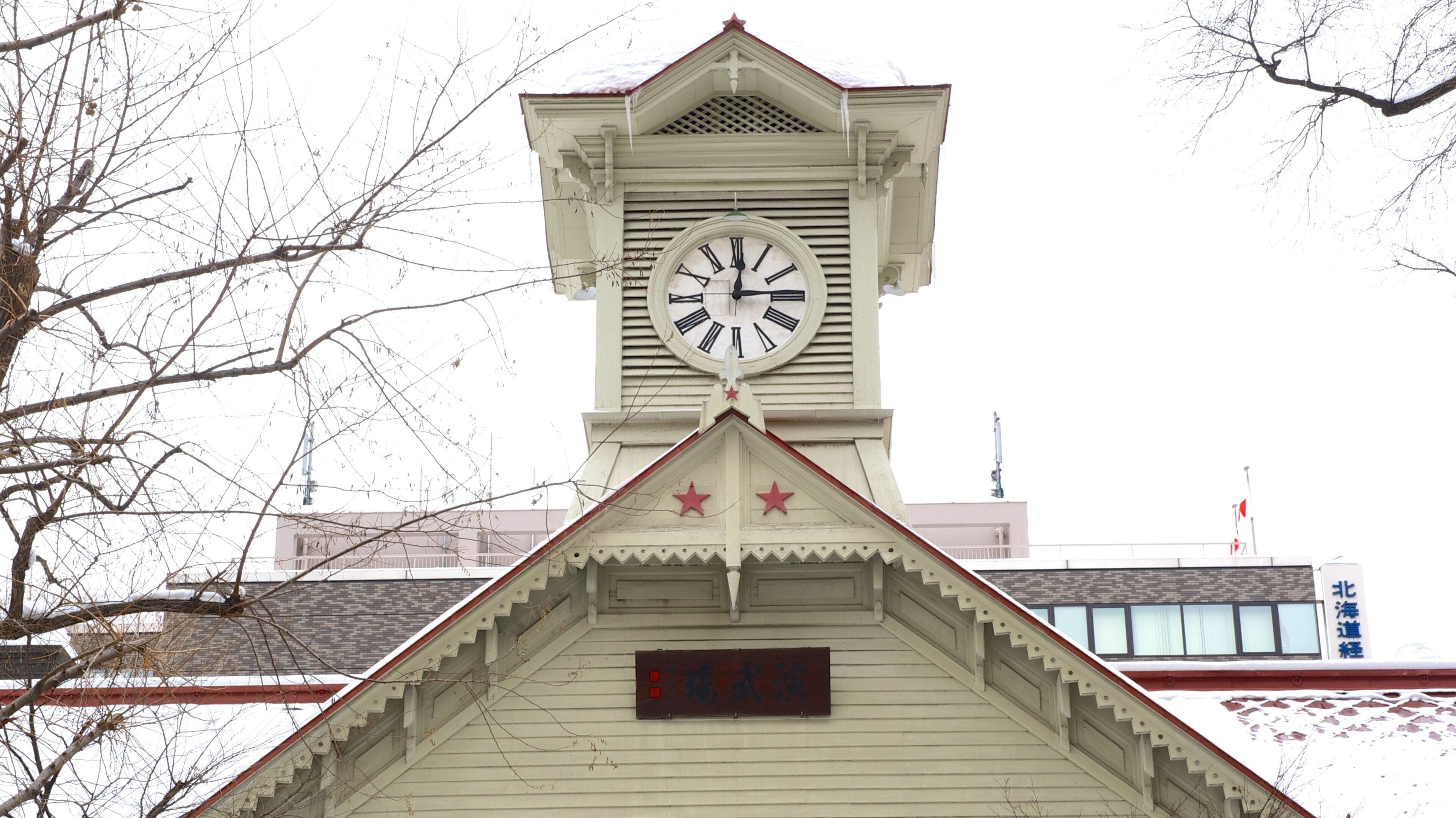 A clock tower with a white clock face and Roman numerals.