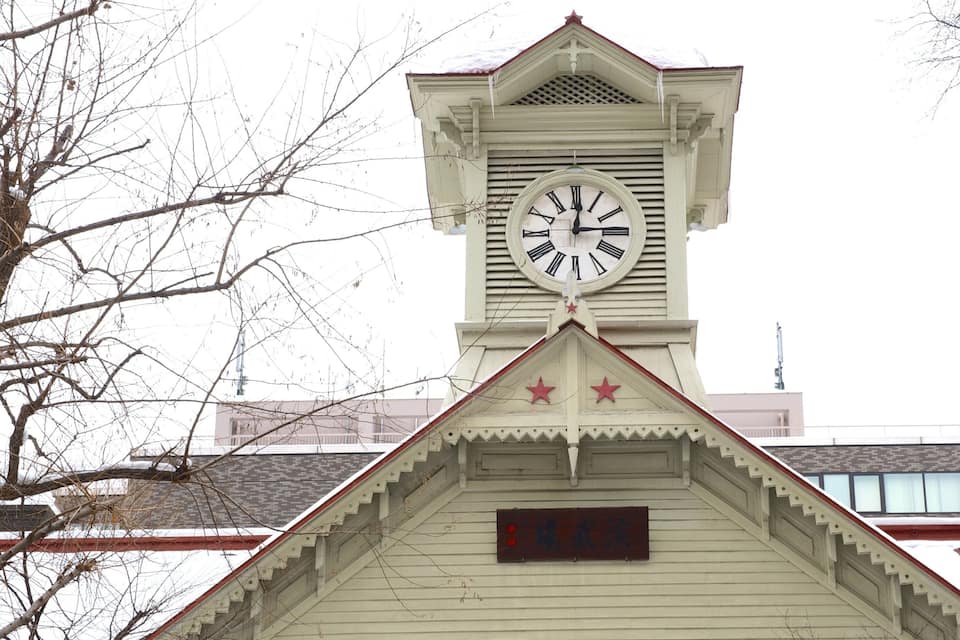 A clock tower with a white clock face and Roman numerals.