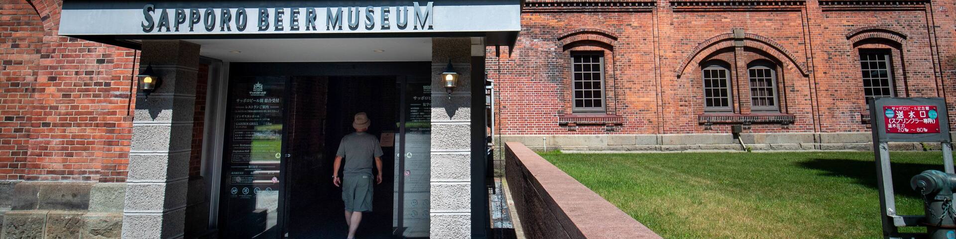 The entrance to the Sapporo Beer Museum with a brick building and a clear blue sky in the background.