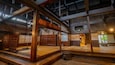 A traditional Japanese interior with tatami flooring, wooden beams, and a shoji screen door.