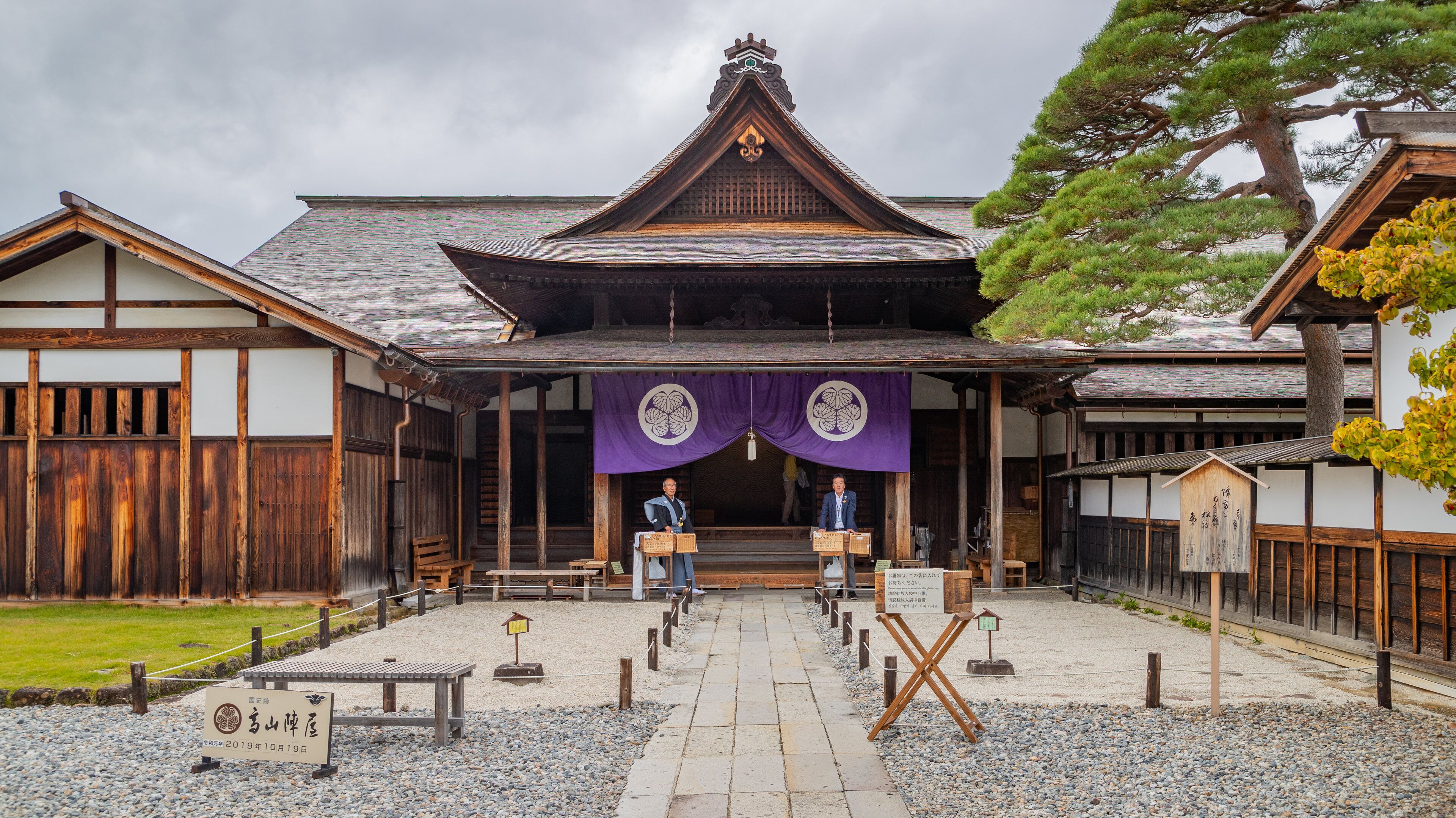 Il s’agit d’un bâtiment traditionnel japonais, doté d’un toit recouvert de tuiles, de poutres en bois et d’une entrée centrale flanquée de deux portes en bois.