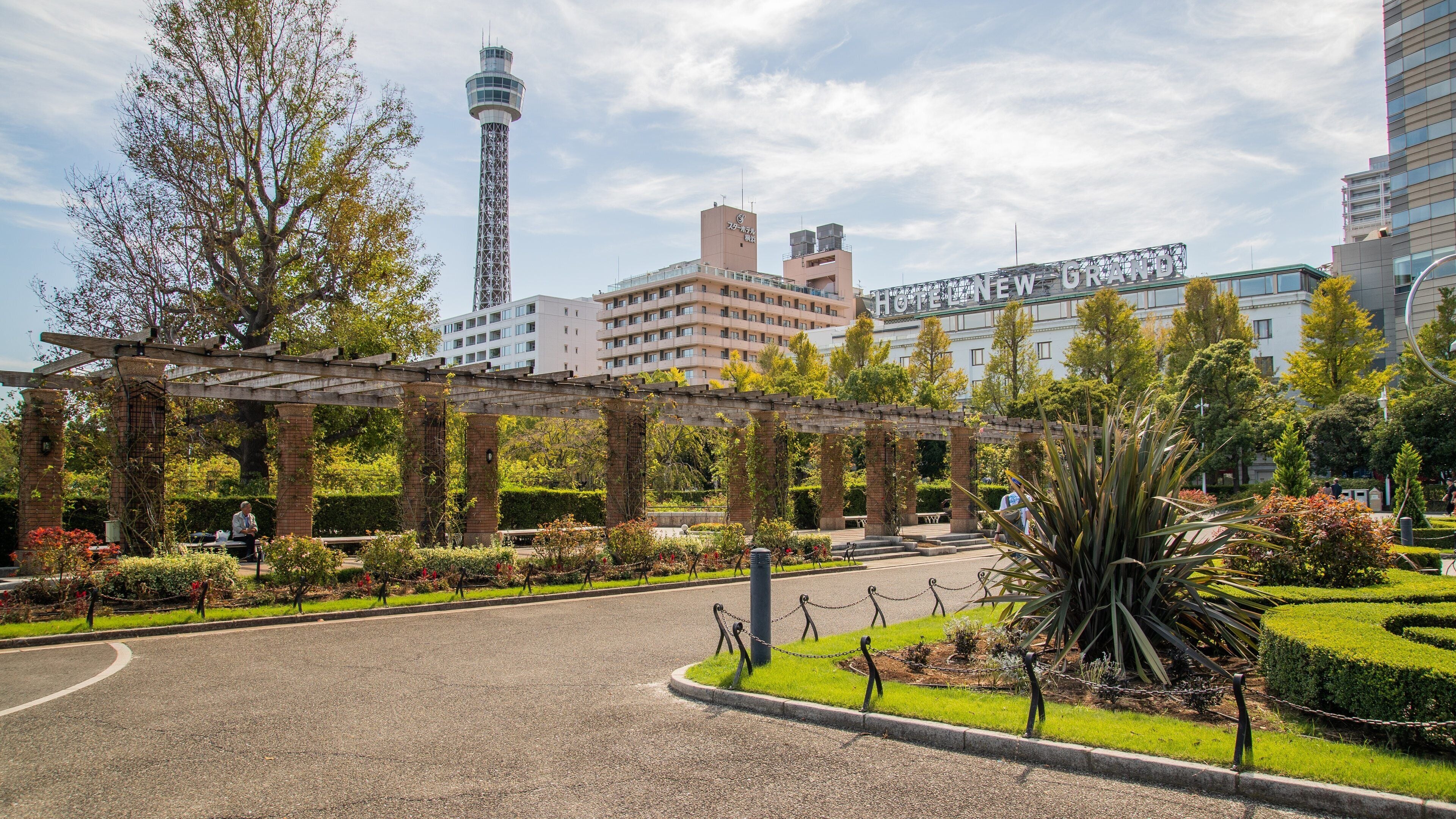 A garden with a pergola, a tower, and a hotel named "NEW GRANDE".