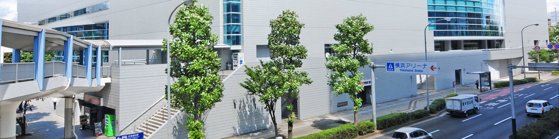 Yokohama Arena with a modern design, featuring large glass windows and a prominent sign.