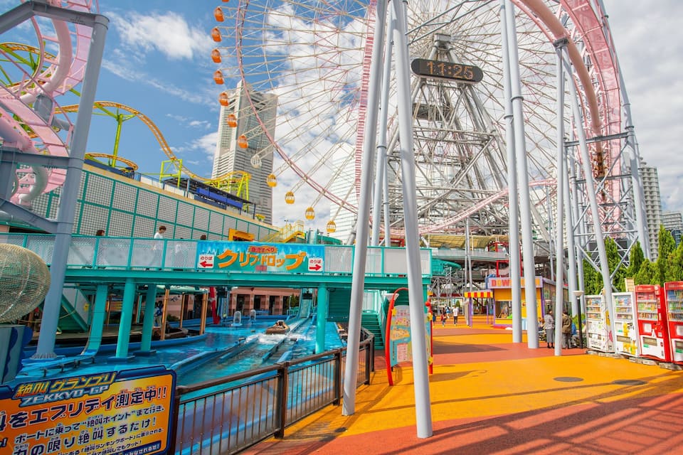 Una noria, una montaña rusa y una atracción acuática en un parque de atracciones.
