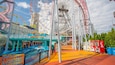 Een reuzenrad, achtbaan en waterattractie in een pretpark.