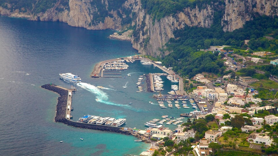 A coastal town with a marina, boats, and a cliffside.