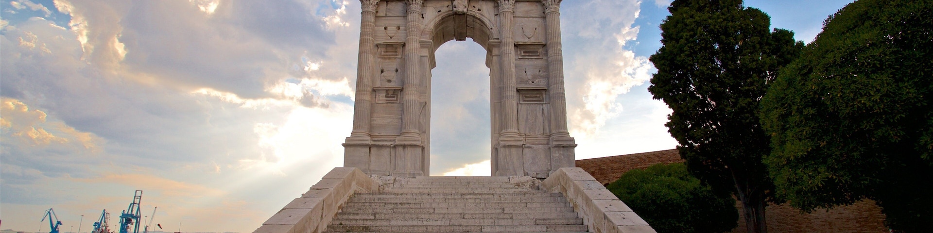 Arco di Traiano mostrando elementos de patrimônio e um pôr do sol