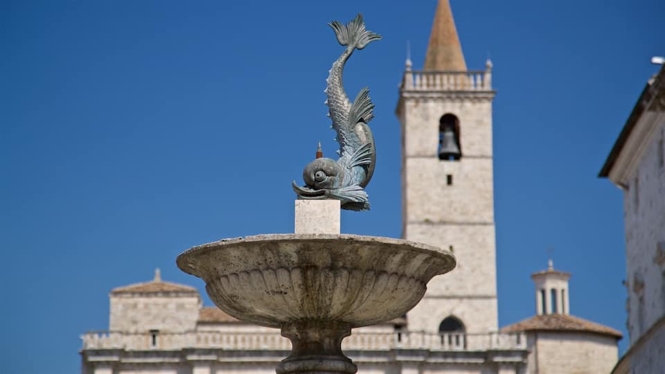 A fountain with a mermaid statue in front of a historic building with a bell tower.