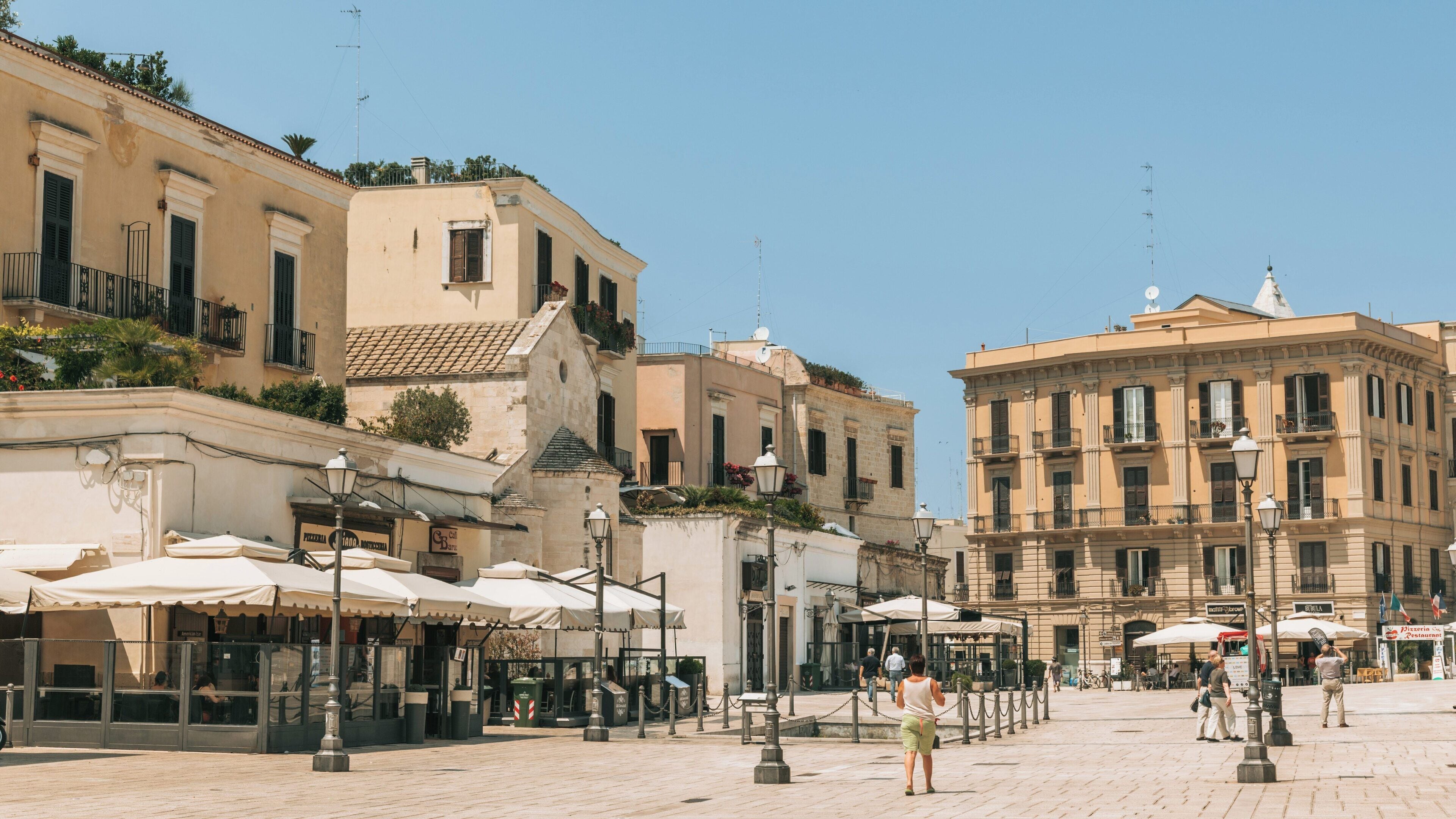 Exploring Piazza del Ferrarese in Bari City Centre with charming architecture and lively cafes in Puglia, Italy on a sunny day