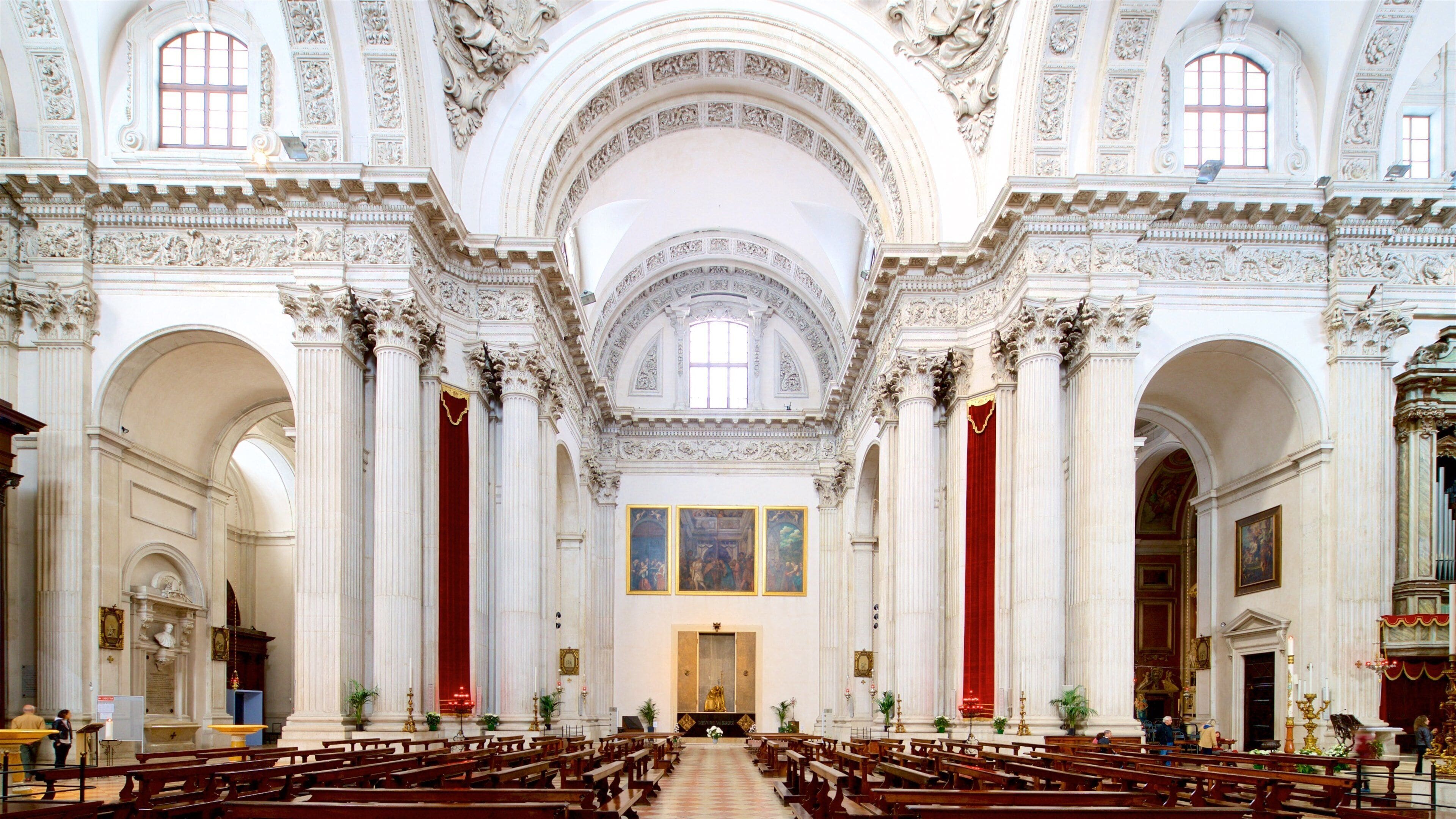 An ornate church interior with high ceilings, red velvet curtains, and classical columns.