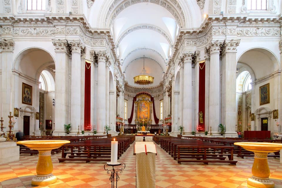 Ein aufwändig gestaltetes Kircheninnere mit hohen Decken, Marmorsäulen und einem zentralen Altar.