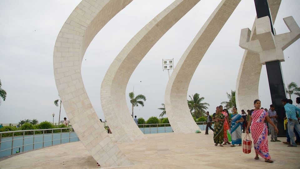A modern architectural structure with curved white pillars and a central black pillar.