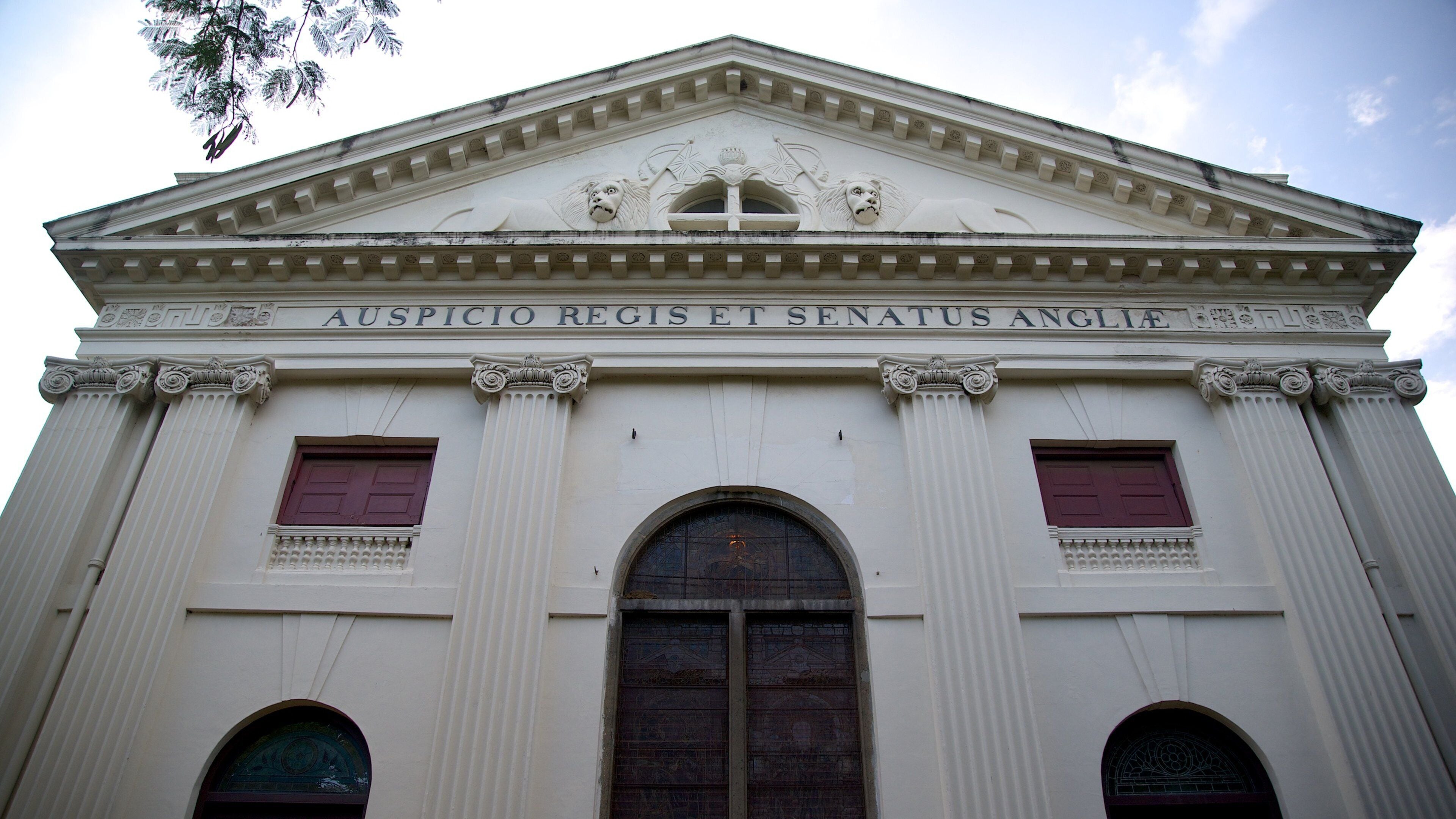 A neoclassical building facade with the inscription "AUSPICIO REGIS ET SENATUS ANGLI."