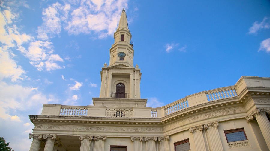 A historic building with a tall tower, classical columns, and a clock.