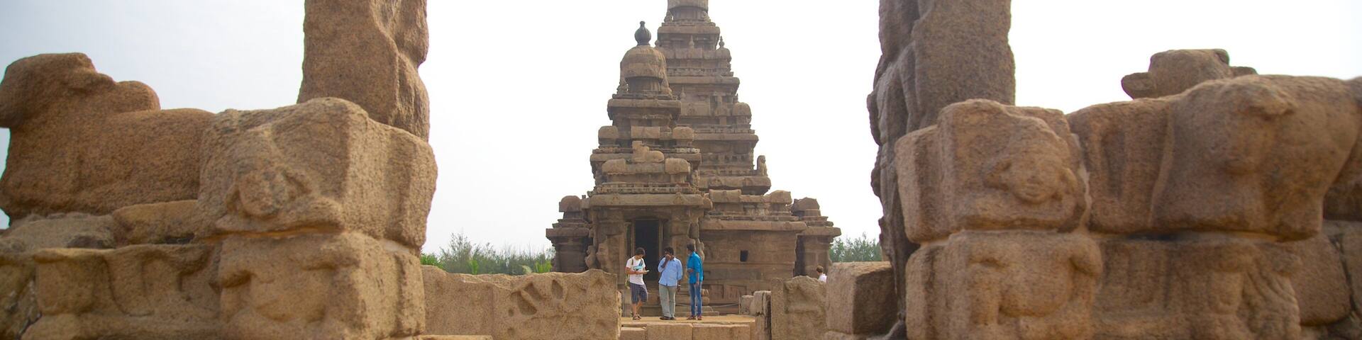 An ancient stone temple with a central tower and two large stone pillars on either side.