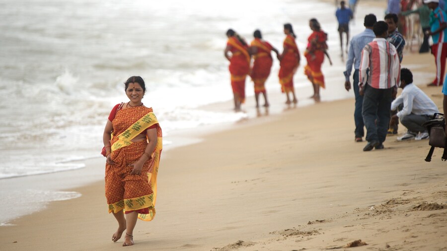 Praia de Mamallapuram mostrando uma praia de areia assim como uma mulher sozinha