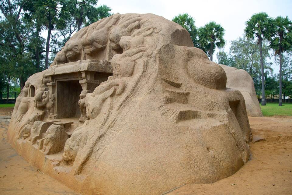 A large sand sculpture of a lion with a cave entrance.