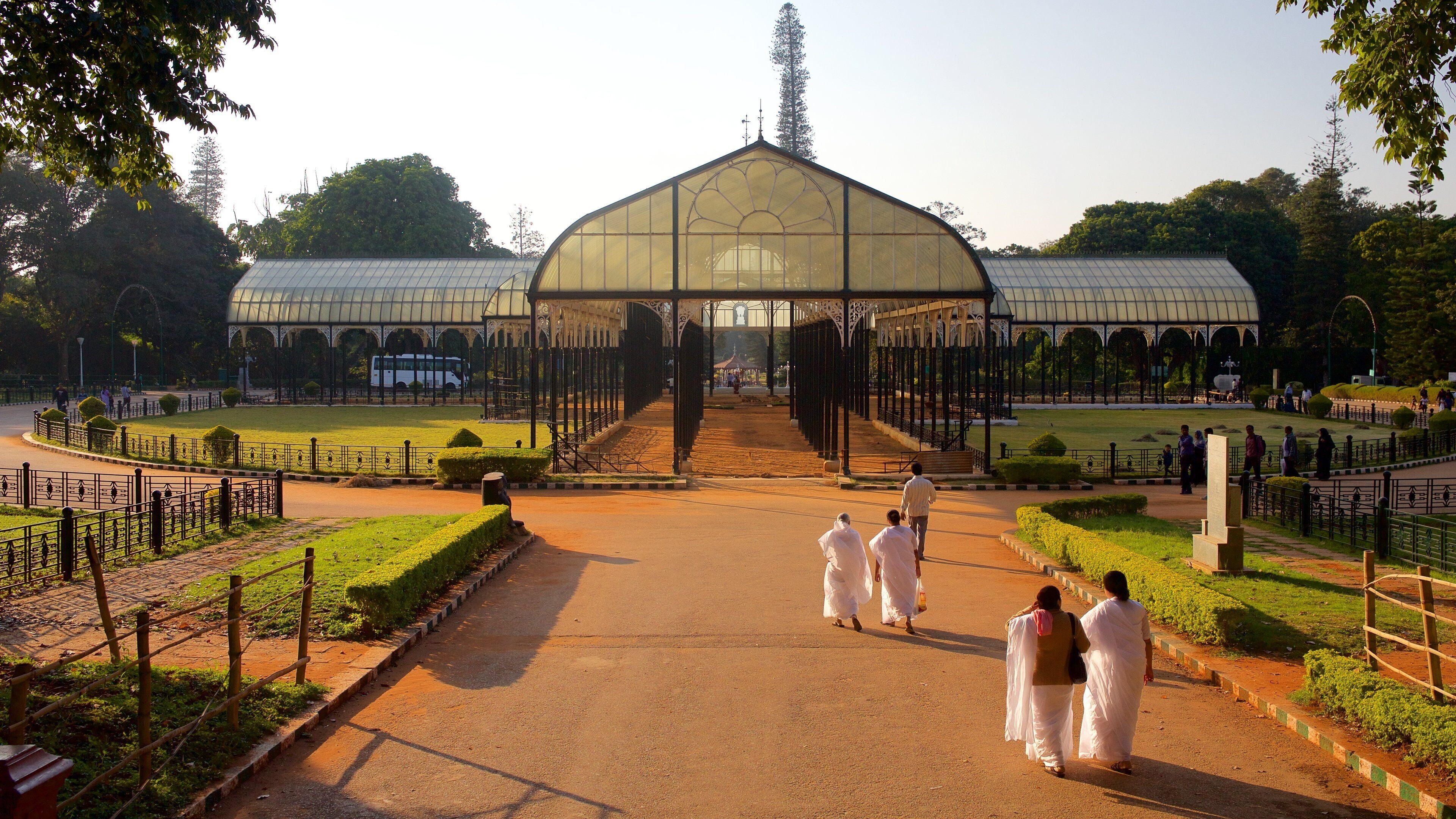 A large glass-domed structure with a central staircase leading to a covered area, surrounded by manicured gardens and pathways.