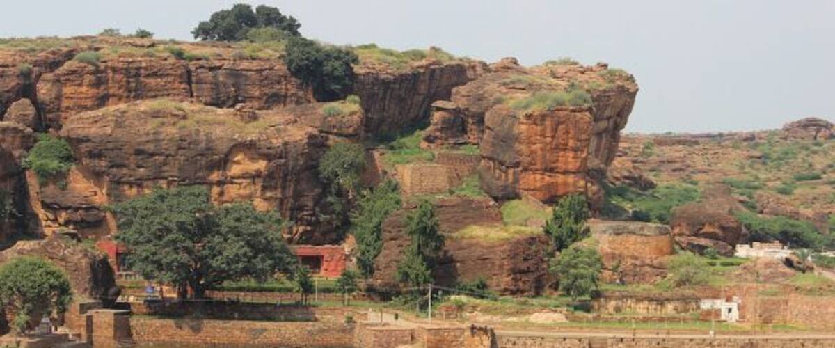 The Agastya Lake is surrounded by hills and reddish sandstone temples, said to have been built in 5th century. The waters of this lake are said to possess healing powers too. The sandstone rocks around this lake have gaps in them that act as pathways to climb up the nearby hill. This view is from Badami caves.