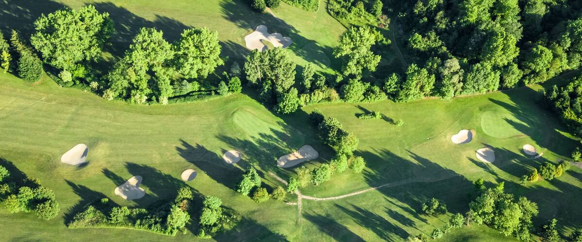 Drone view of a beautiful golf course at sunset with shadows and shapes