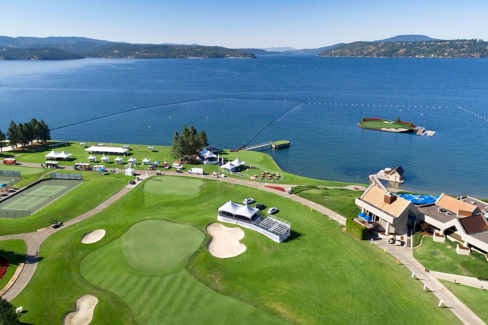 A golf course with a lake, a bridge, and a small island.