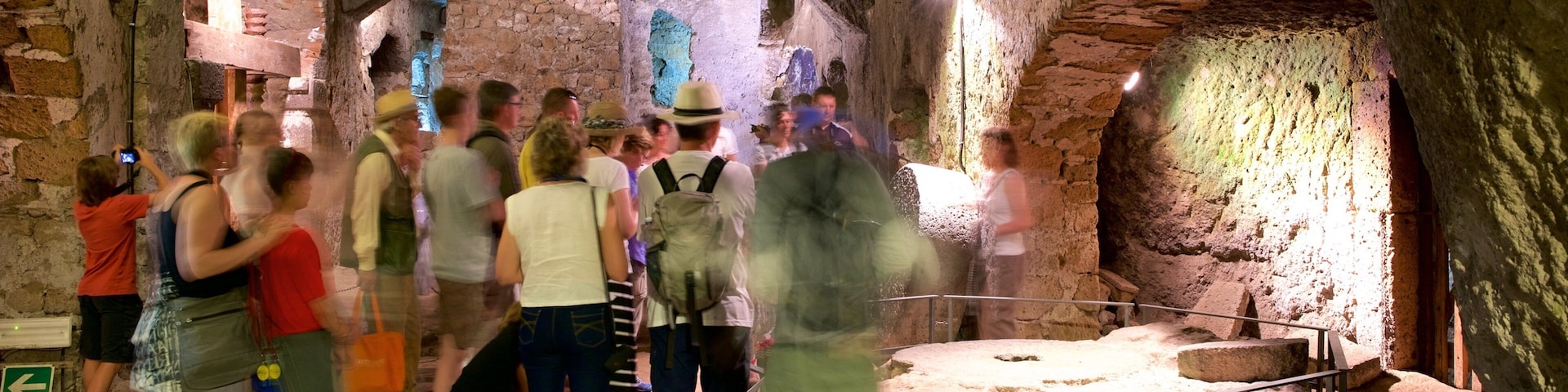 Subterrâneos Etruscos de Orvieto caracterizando vistas internas e cavernas assim como um grande grupo de pessoas