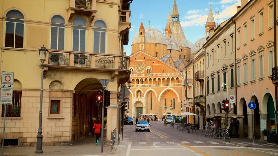 A street with historic buildings, a church with domes, and a pedestrian crossing.