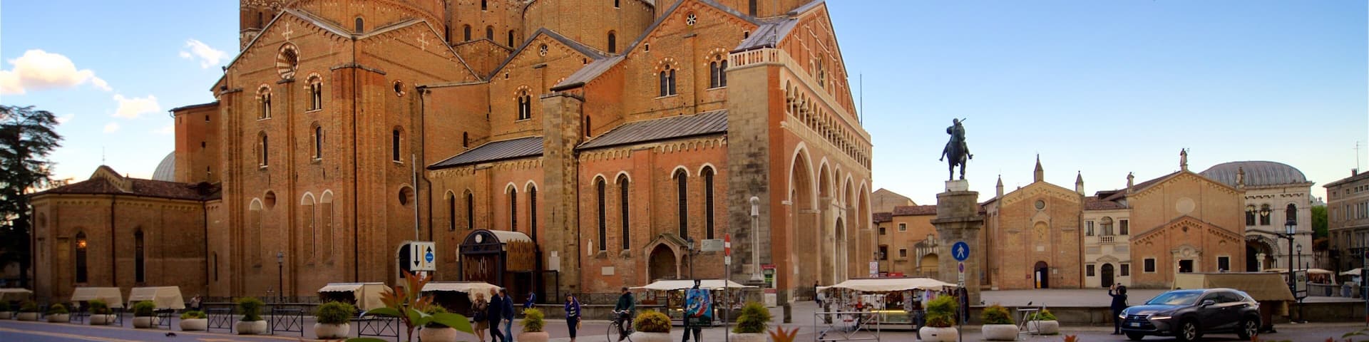 A historic cathedral with multiple domes and a statue in front.